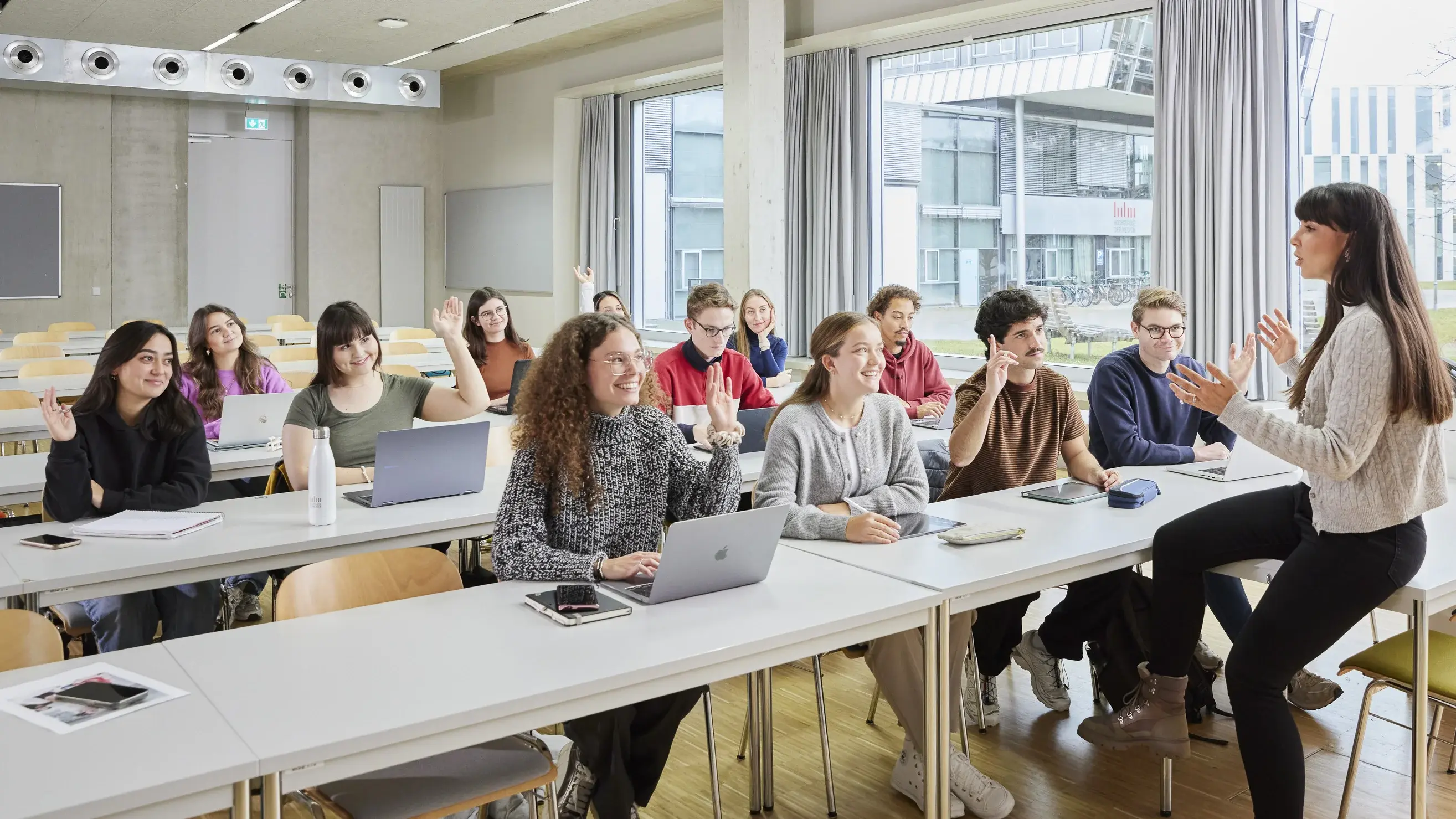 Ein Professor mit seinen Studierenden in der Vorlesung.
